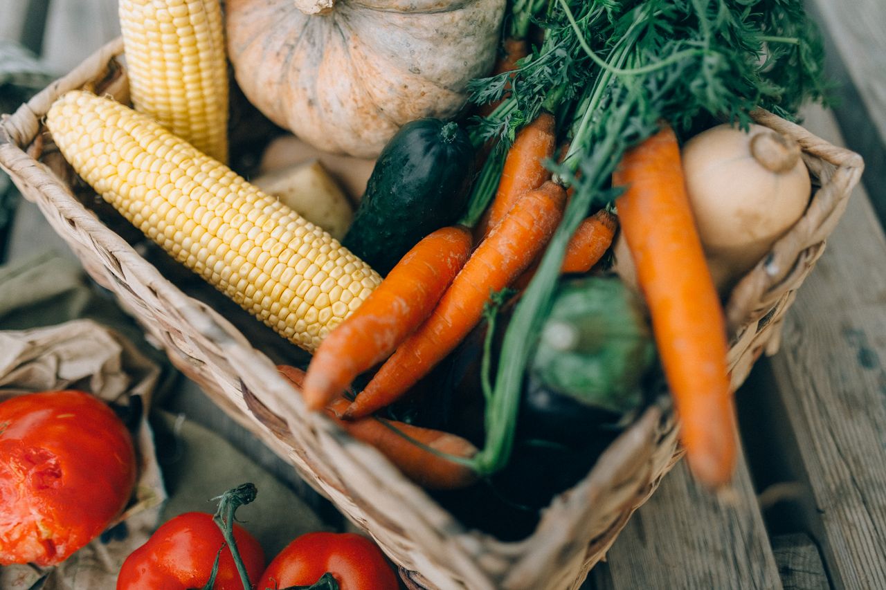 A close-up of fresh organic vegetables in a wicker basket, perfect for healthy eating.